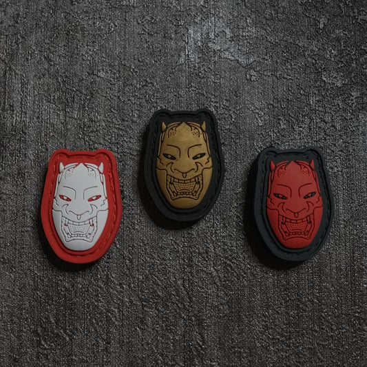 Three decorative patches with unique designs on a textured dark surface